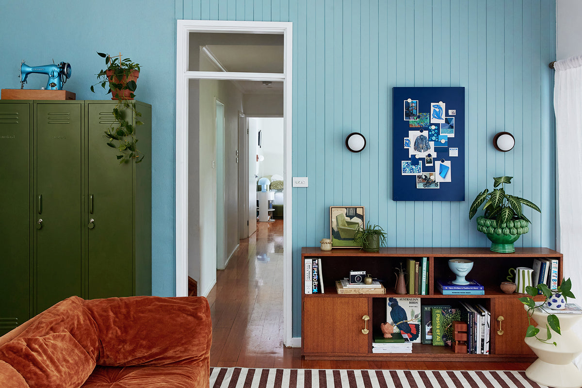 A living room with Ocean blue panelled walls, three Skinny lockers in Olive and a Navy Storyboard pinboard, styled in a 60-30-10 colour palette