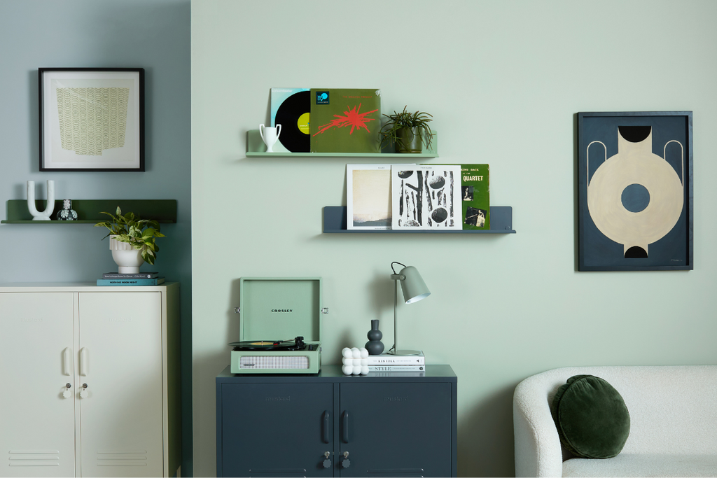 A living room setting showing The Lowdown in Slate and The Midi in Chalk against a sage green wall. Two Ledges hang on the wall, as well as two pieces of artwork.