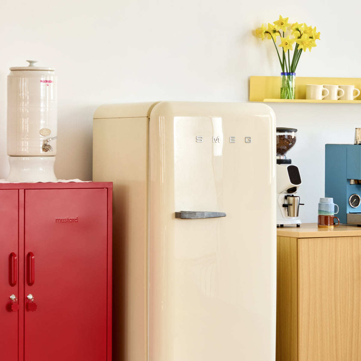 The Midi locker in Poppy red beside a cream retro fridge in a kitchen