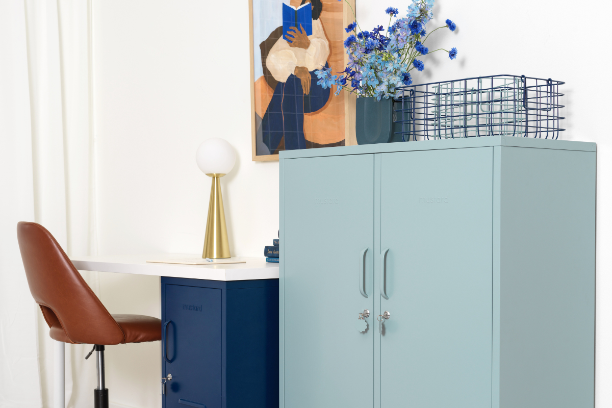 Un Ocean Midi se encuentra junto a un escritorio y una silla de oficina en un elegante espacio de trabajo. En la pared hay una obra de arte en tonos azules y tierra.