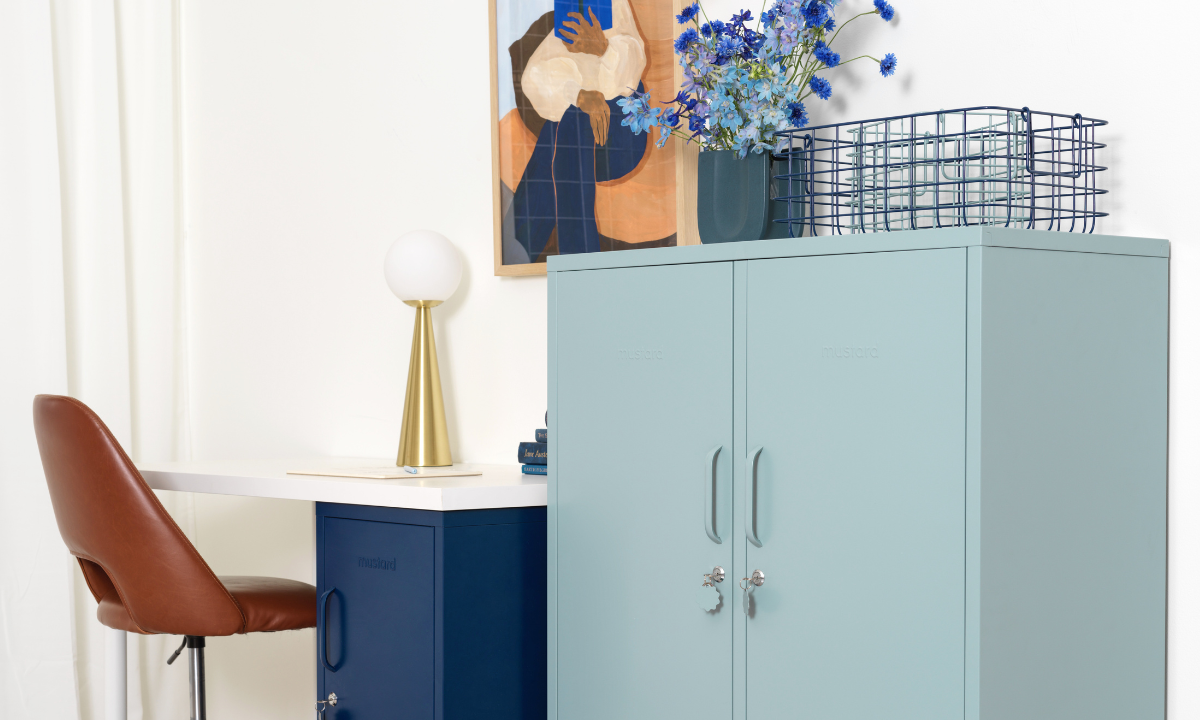 Un Ocean Midi est posé à côté d'un bureau et d'une chaise de bureau dans un espace de travail élégant. Le mur est orné d'une œuvre d'art aux tons bleus et terreux.